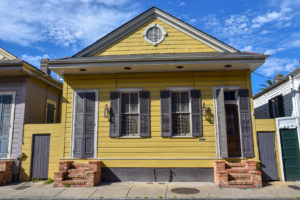 Yellow shotgun house in the French quarter of New Orleans, LA| Foundation repair, termite damage repair, structural repair, wall removal, beam installation, house raising, construction framing, house leveling, residential construction, commercial construction, www.RichardEarlsConstruction.com